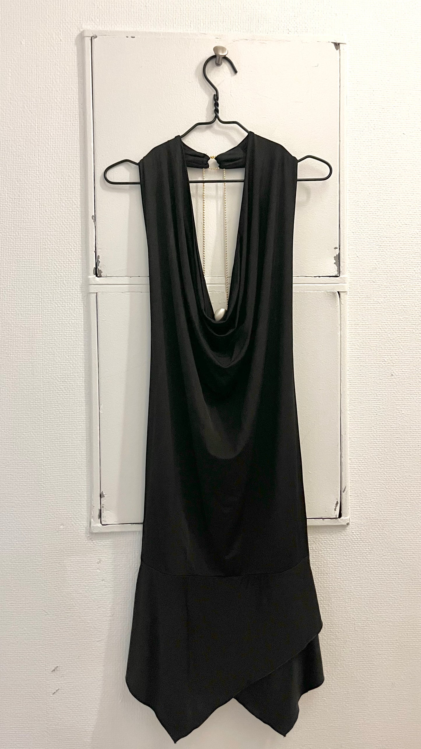 Elegant sort backless kjole i strækbar jersey materiale med med åben ryg og draperet halsudskæring – perfekt cocktail kjole til festlige anledninger og tidløse looks. 